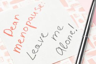 Handwritten note reading “Dear Menopause: Leave me alone!” next to a pen.