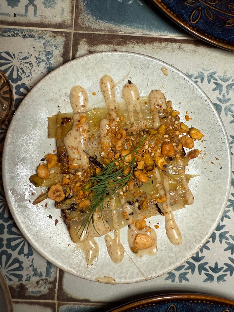 Grilled leeks with date vinaigrette and nut dukkah at Al-Andalus NYC