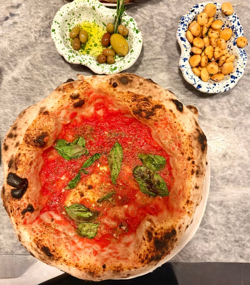 Vegan spread at Una Pizza Napoletana featuring marinara pizza, olives, lupini beans