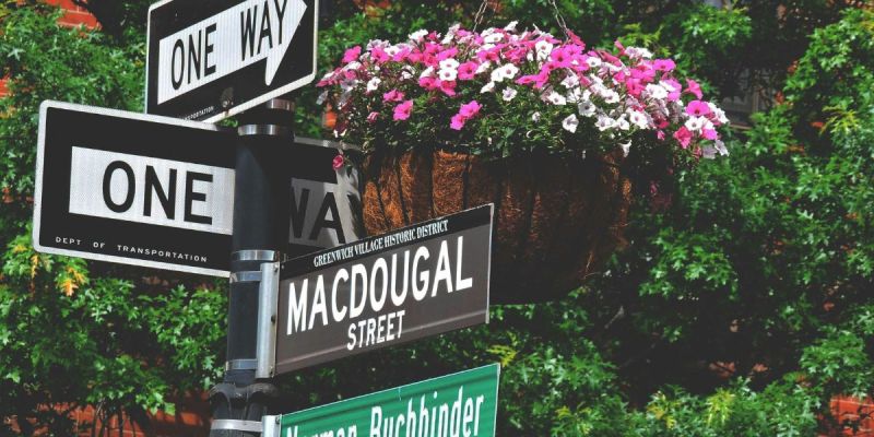 Street signs on MacDougal Street in the West Village, a historic and walkable NYC neighborhood